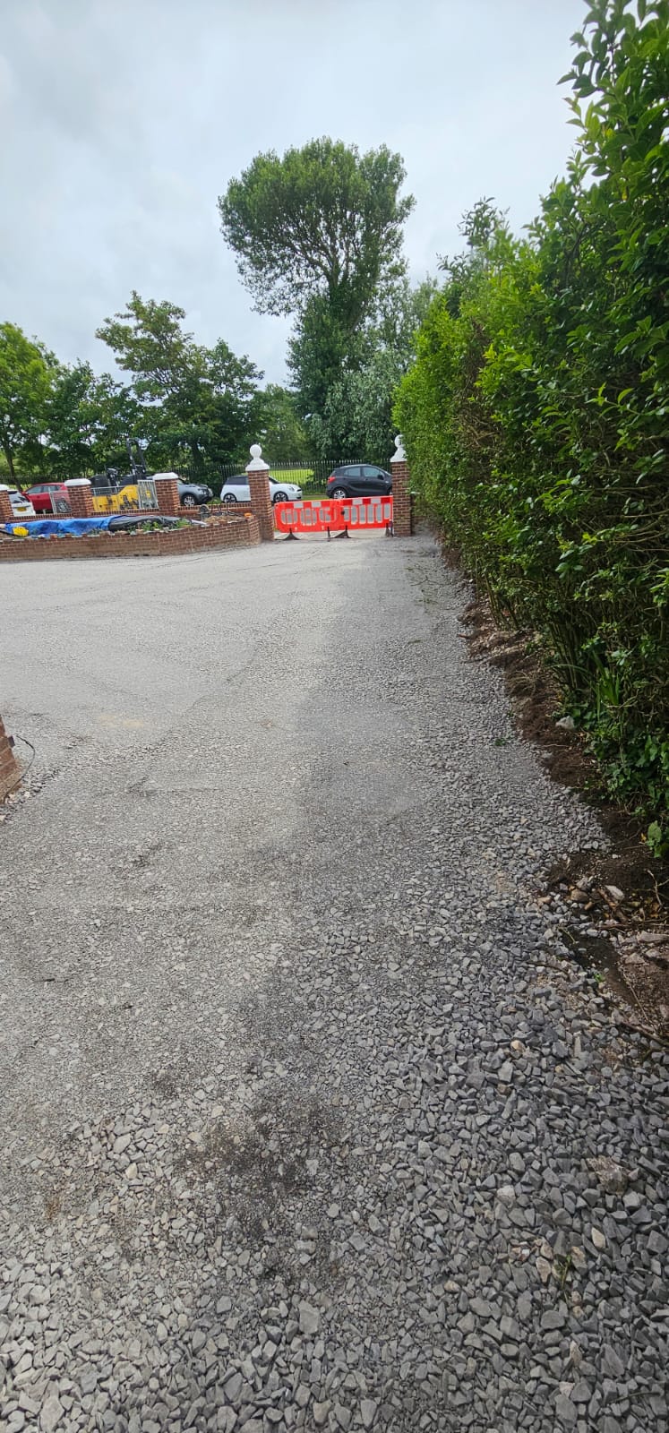 Finished driveway entrance from the road through brick gate pillars