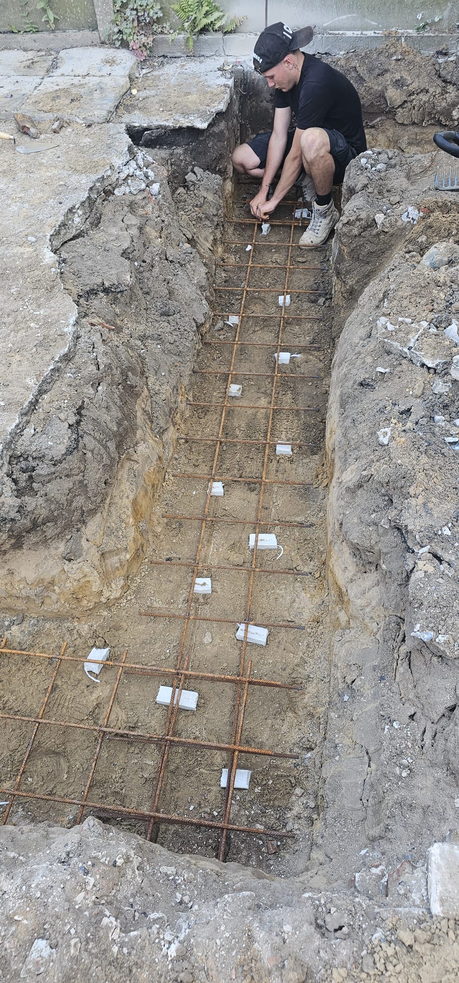 DSG Groundworks operative tying steel rebar in a foundation trench, Blackpool