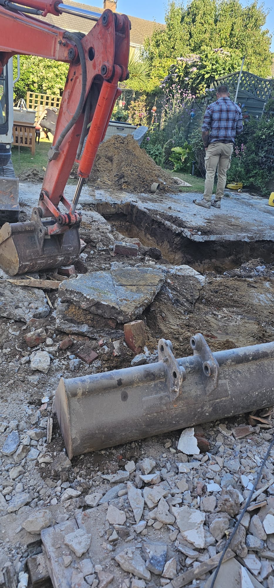 Mini excavator breaking ground and lifting old concrete on a Blackpool groundworks site by DSG Groundworks